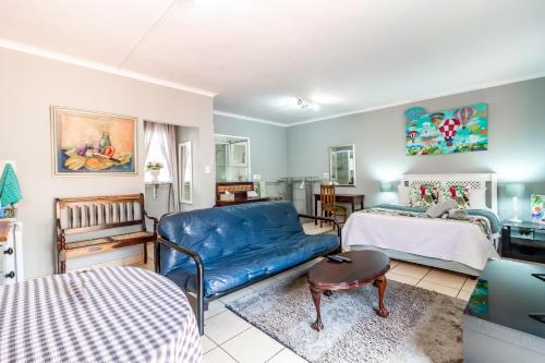 a living room with a couch and a bed at Berghaan Pretoria in Pretoria