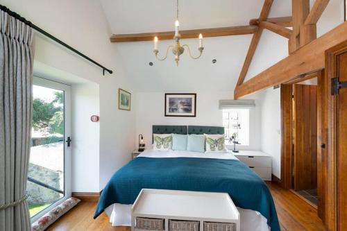 ein Schlafzimmer mit einem großen Bett mit einer blauen Decke in der Unterkunft Long Roods cottage in Bakewell