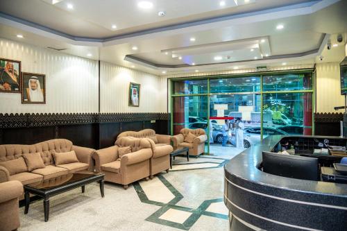 a waiting room with couches and a bar at Qaser Alhamra Serviced apartments in Riyadh