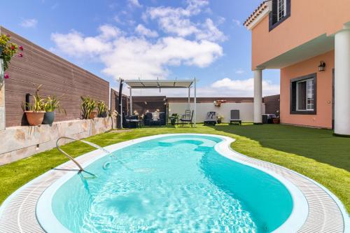 拉斯帕爾馬斯的住宿－Villa Samperez Piscina Jardin 5 Dormitorios 12 Personas，一座房子后院的游泳池