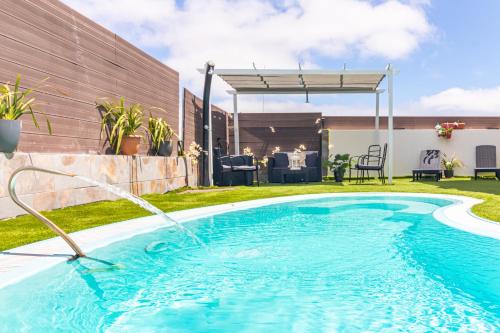 - une piscine avec un tuyau d'eau dans la cour dans l'établissement Villa Samperez Piscina Jardin 5 Dormitorios 12 Personas, à Las Palmas de Gran Canaria