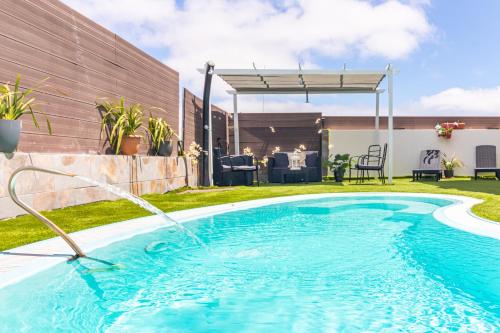 a swimming pool with a water hose in a yard at Villa Samperez Piscina Jardin 5 Dormitorios 12 Personas in Las Palmas de Gran Canaria