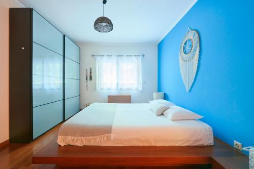 a bedroom with blue walls and a large bed at Sunny apartament at Carcavelos Beach, by TimeCooler in Carcavelos