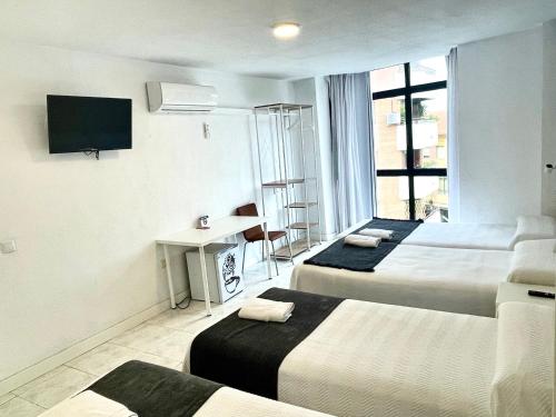 Habitación de hotel con 3 camas y TV en Pension Venecia en Pinto