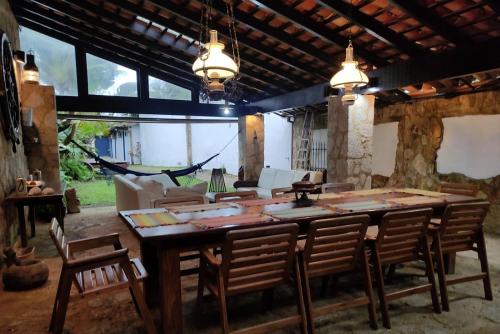 a dining room with a large wooden table and chairs at Casa rústica centenária no Centro Histórico de Paraty - Wifi 120MB in Paraty