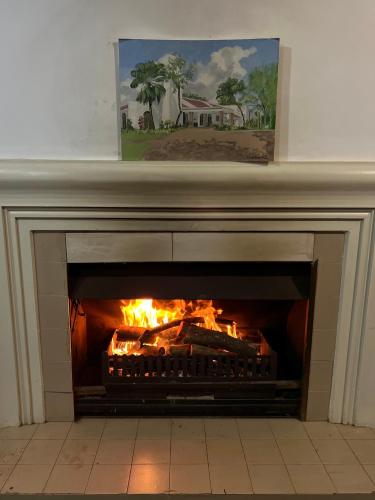 a fireplace with a fire inside of it at The Sunbird Guesthouse in Gingindlovu