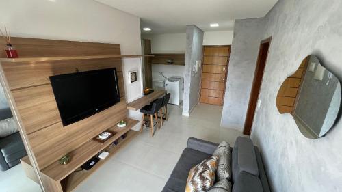 uma sala de estar com uma televisão de ecrã plano e um sofá em Apartamento em prédio residencial em FOZ DO IGUAÇU em Foz do Iguaçu
