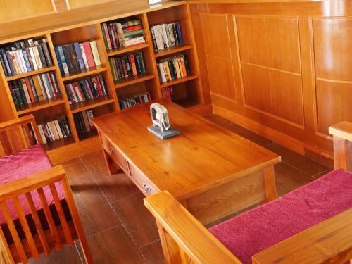 a library with a wooden table and shelves of books at The Sunset Beach Resort - Koh Kho Khao in Ko Kho Khao