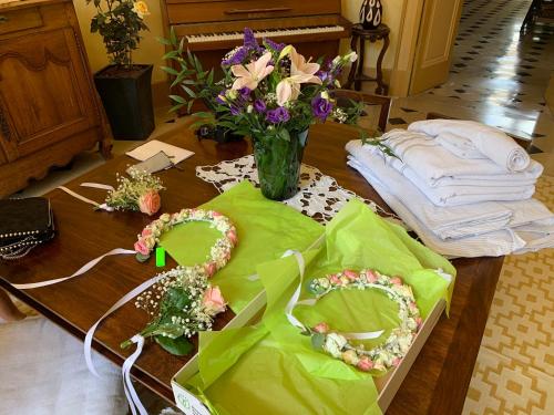 a table with green bags and a vase of flowers at La Grande Maison in Seine-Port