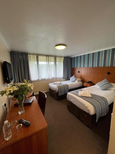 a hotel room with two beds and a table at Hermitage Park Hotel in Coalville