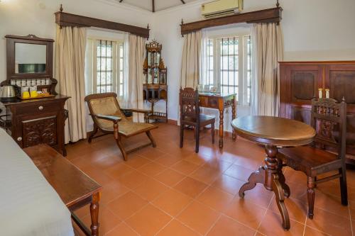 a living room with wooden furniture and a table and chairs at MAI HOUSE HERITAGE HOTEL in Fort Kochi