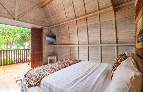 a bedroom with a large bed in a room with wooden walls at Sunsets at Sumbul in Pulukan
