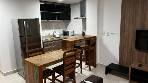 eine Küche mit einem Holztisch und einem Kühlschrank in der Unterkunft Flat Brookfield Towers 2309 in Goiânia