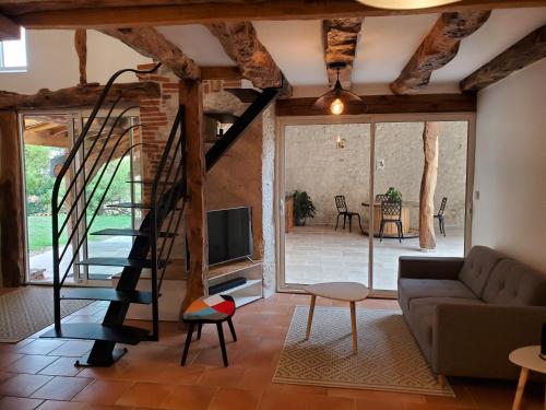 a living room with a staircase and a couch at Gite Pierre qui roule in Castanet