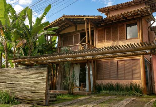 une vieille maison avec une clôture devant elle dans l'établissement Casa da Arquiteta Guest House, à Ilhabela