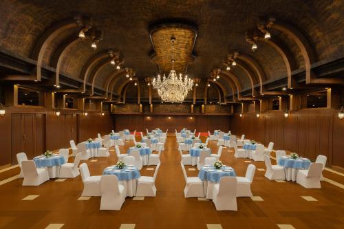 a banquet hall with white tables and chairs and a chandelier at Fortune Valley View, Manipal - Member ITC Hotels' Group in Manipala
