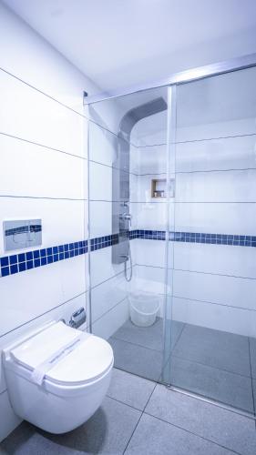 a bathroom with a toilet and a glass shower at MAI HOUSE HERITAGE HOTEL in Fort Kochi