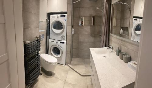 a bathroom with a washing machine and a washer and dryer at Prestige Aquapark Apartments - Aquatower in Reda