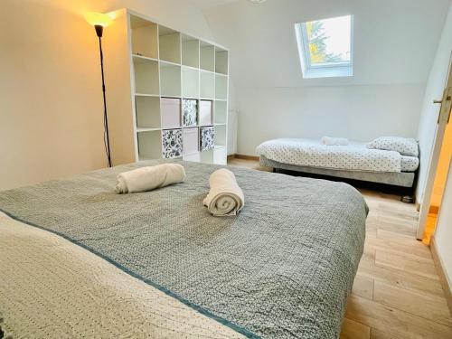 een slaapkamer met een bed met een handdoek erop bij VILLA GIULIA - 5min Roissy Airport - 20min Disney in Gressy