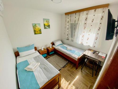 Habitación pequeña con 2 camas y mesa. en Kuća za odmor ,,Valvero’’, en Vrbanja