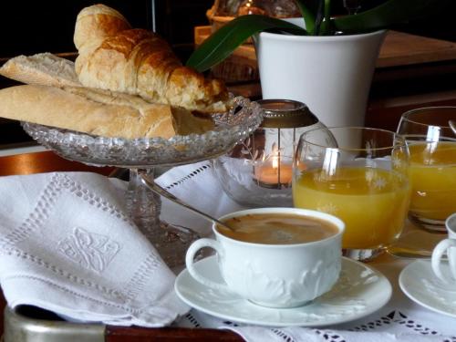 a table with a cup of coffee and a plate of bread at La Grande Maison in Seine-Port
