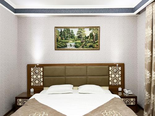 a bedroom with a bed and a picture on the wall at Reikartz Xon Tashkent in Tashkent