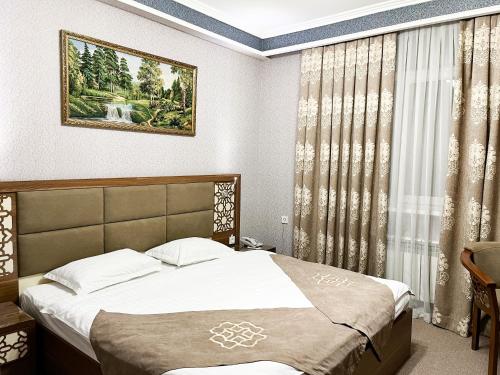 a bedroom with a bed and a window at Reikartz Xon Tashkent in Tashkent