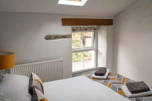 Schlafzimmer mit einem Bett und einem Fenster in der Unterkunft Quinta Cottage in Soutergate