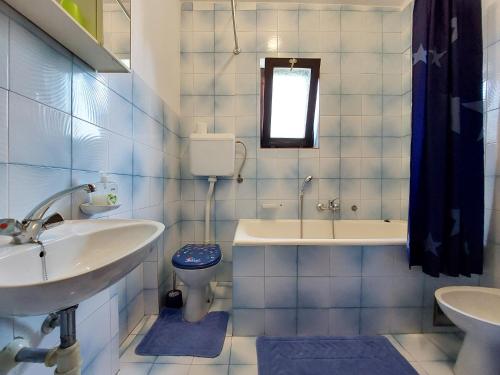 a bathroom with a sink and a toilet and a tub at Apartments Vilim in Pinezici