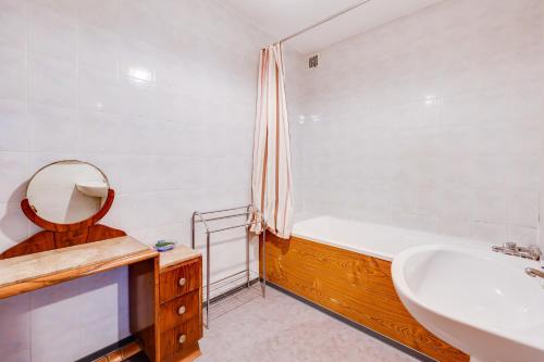 een badkamer met een bad, een wastafel en een spiegel bij Maison de 3 chambres avec piscine partagee terrasse amenagee et wifi a Lagrasse in Lagrasse