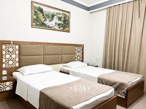 a hotel room with two beds and a painting on the wall at Reikartz Xon Tashkent in Tashkent