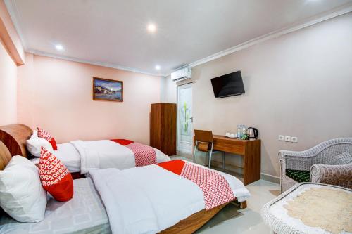 Cette chambre comprend deux lits et une télévision. dans l'établissement OYO 90857 Baaraka Syariah Hotel, à Pekanbaru