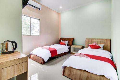 - une chambre avec 2 lits et une fenêtre dans l'établissement OYO 90857 Baaraka Syariah Hotel, à Pekanbaru