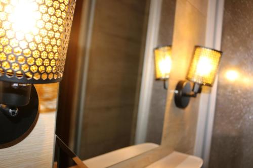 two lights on a wall next to a mirror at Hotel Berliner Hof in Düsseldorf