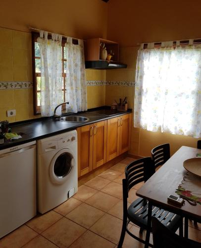 cocina con lavadora y mesa con sillas en Casa Dos Aguas, en Garafía
