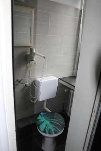 a small bathroom with a toilet with a green seat at Hotel Berliner Hof in Düsseldorf