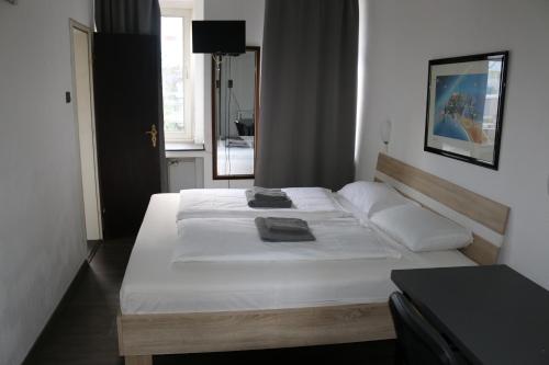 1 dormitorio con 1 cama grande con sábanas blancas en Hotel Berliner Hof, en Düsseldorf