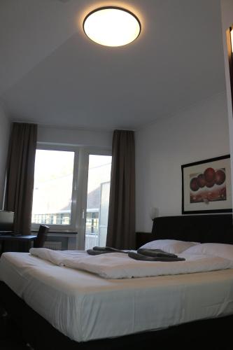 a bedroom with a bed with a large window at Hotel Berliner Hof in Düsseldorf
