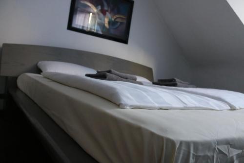 a bed with white sheets and pillows on it at Hotel Berliner Hof in Düsseldorf