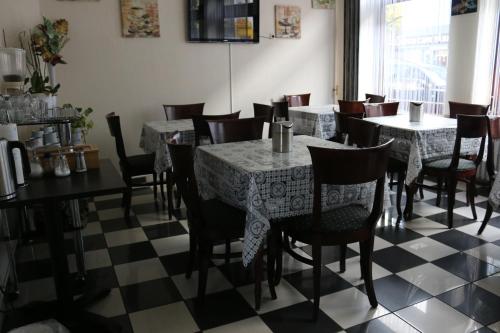 a restaurant with tables and chairs on a checkered floor at Hotel Berliner Hof in Düsseldorf