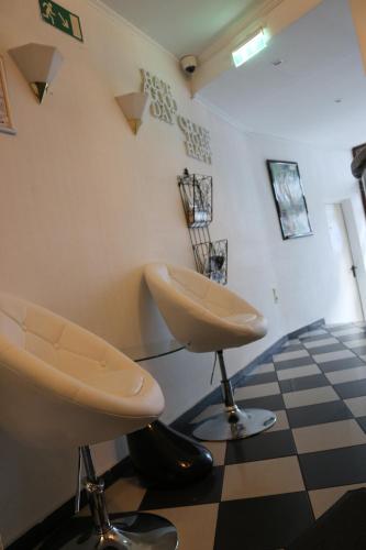 a waiting room with two chairs and a checkered floor at Hotel Berliner Hof in Düsseldorf