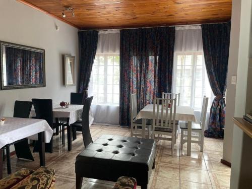 イースト・ロンドンにあるamazing grace guesthouseのテーブルと椅子と窓のあるダイニングルーム