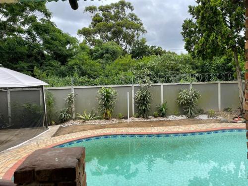 a swimming pool in a backyard with a fence at amazing grace guesthouse in East London