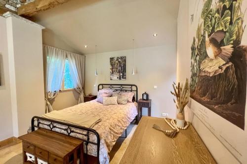 a bedroom with a bed and a painting on the wall at Beautiful guest house for two people on the bank of the Dordogne river in Siorac-en-Périgord