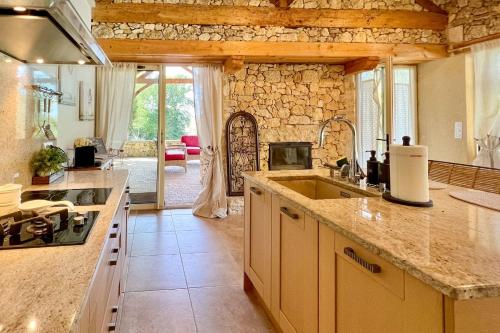 a kitchen with a sink and a counter top at Beautiful guest house for two people on the bank of the Dordogne river in Siorac-en-Périgord
