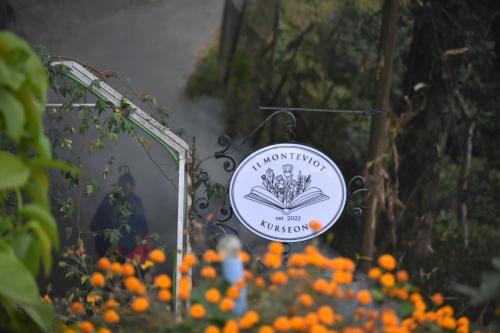 a sign for a garden with orange flowers at 11 Monteviot: Luxury homestay overlooking a tea estate in Kurseong