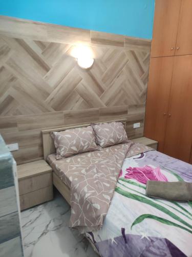 a small bedroom with a bed with a wooden headboard at GCM 2 ROOMS kentro in Katerini