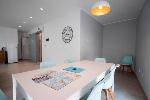 a white dining room with a white table and chairs at The Three Trees Apartments in Sliema