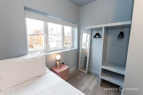 a small bedroom with a bed and a window at New & Unique 1bed, near Bournemouth Beach and Town Centre - Beachy Keen in Bournemouth