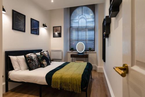 um pequeno quarto com uma cama e uma janela em The City Escape - 5* stay in the heart of Glasgow! em Glasgow